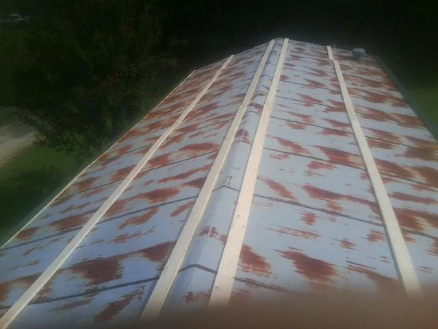 Rusted metal roof panels with new wood purlins before replacement — Storm Damage Roof Repair in Gully by Roofing Brothers