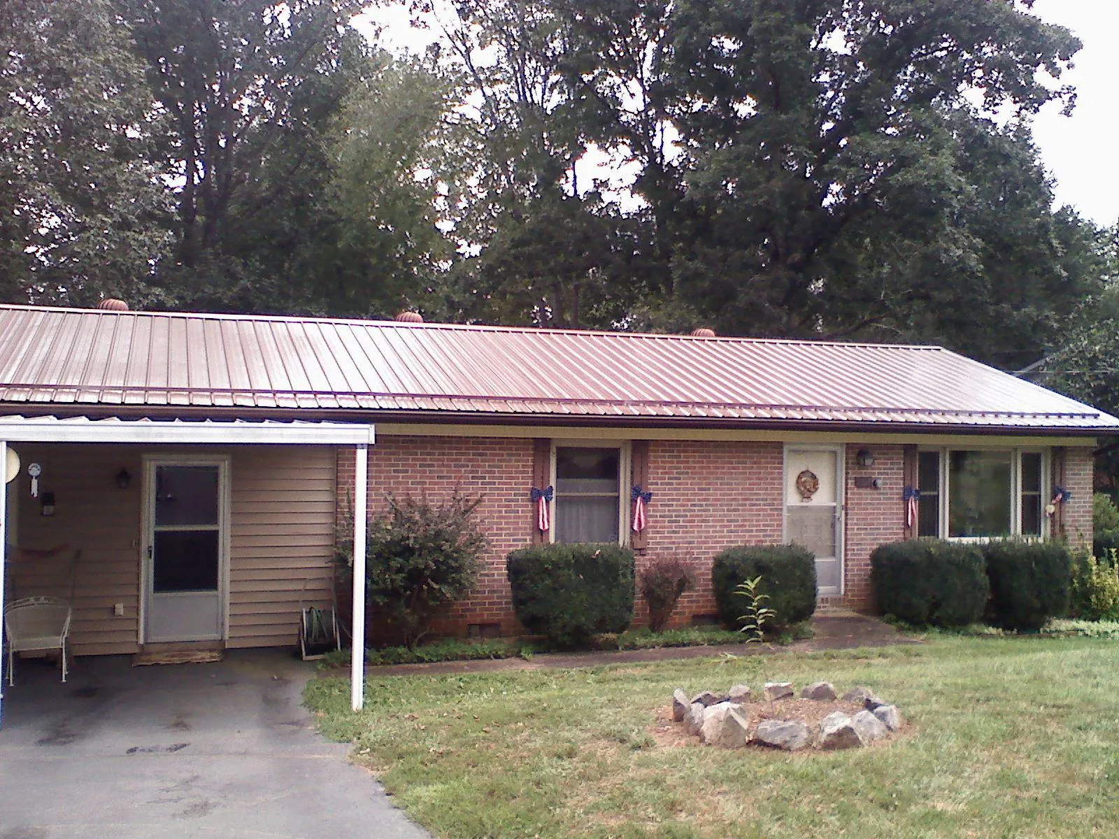 Bronze metal roof and carport on a brick ranch home — Roof Repair work by our crew in Gully